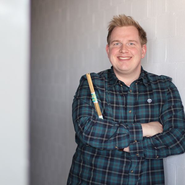 Mitarbeiter lehnt an einer Wand
