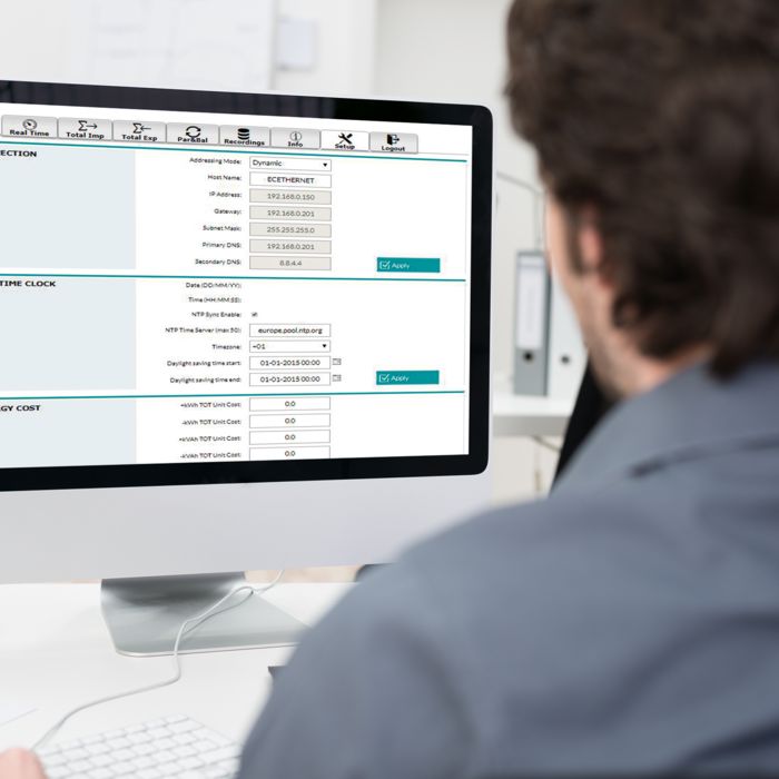 Pillantás egy személy válla fölött, aki az EMpro energiamérők webszerverével ellátott PC képernyője előtt áll