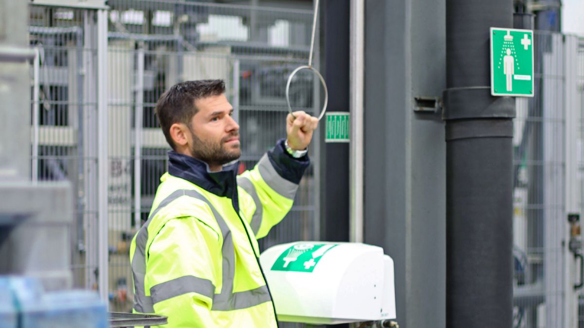 Azionamento di una doccia di emergenza da parte dei dipendenti in un impianto dell'industria di processo