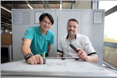 Portrait of two people performing tests on a connector in the laboratory