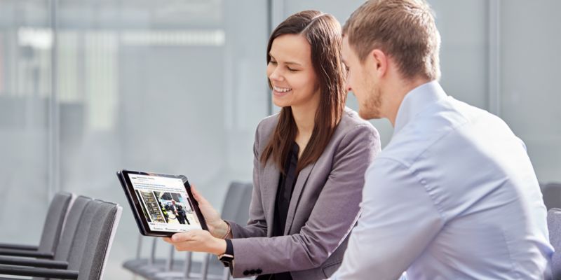 Deux personnes regardent un post LinkedIn sur la tablette