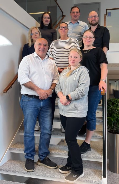 Bild med människor som står i grupp.