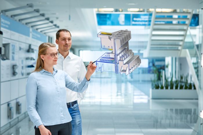 Empleada y cliente con el modelo 3D de un nuevo desarrollo personalizado