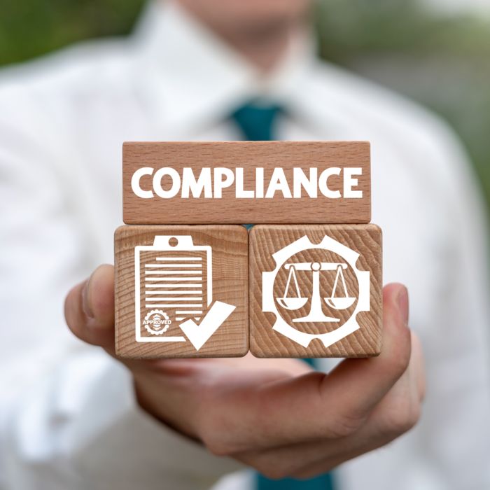アイコンと「Compliance」の文字が入った3つの立方体を手にする人