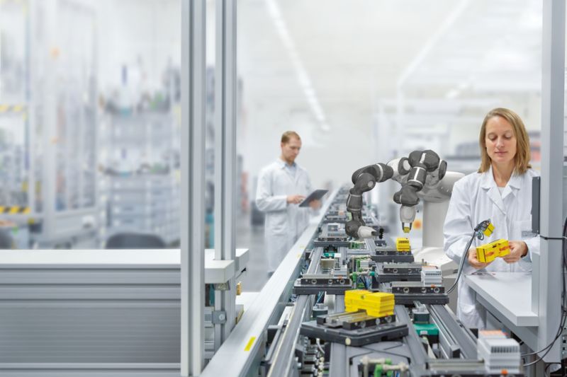 To ansatte på en produksjonslinje med coboter