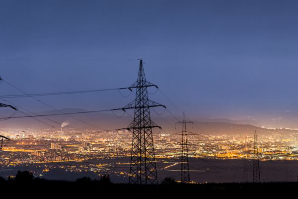 Vue sur les pylônes électriques et les lumières d'une grande ville