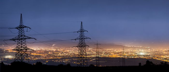 Substation in the dark in front of a city