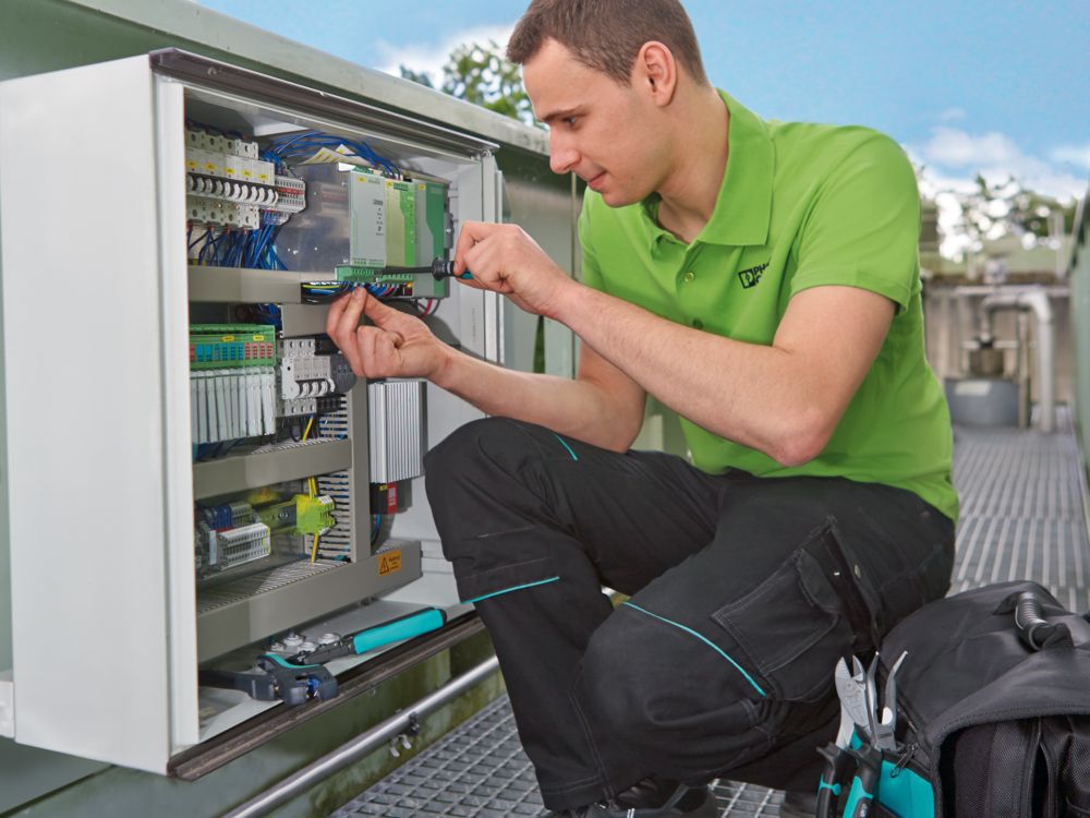 Personnel de maintenance au niveau du coffret électrique du bassin de décantation des boues