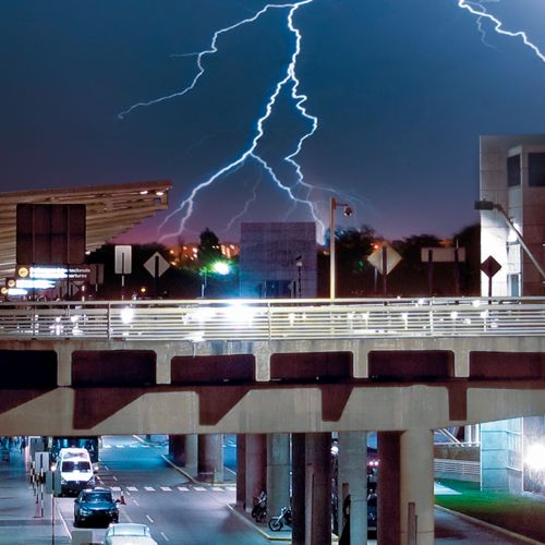 Cidade à noite envolta numa tempestade de relâmpagos