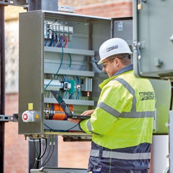 An employee working on a control cabinet