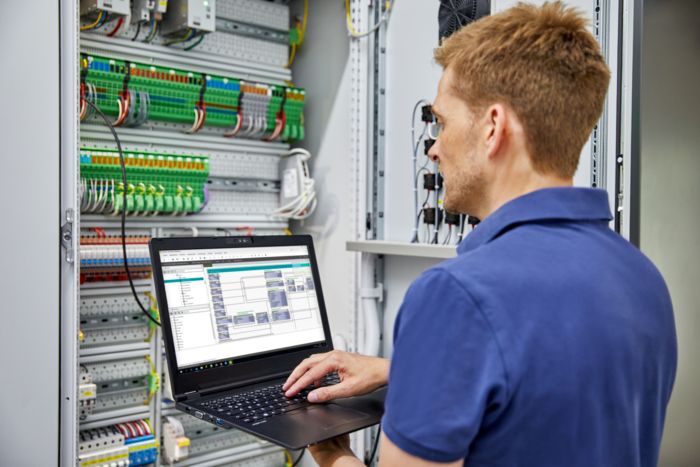 Intégrateur de système de gestion technique centralisée devant une armoire électrique