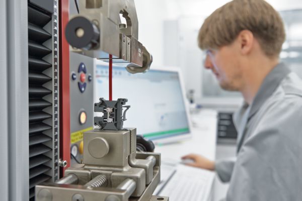 Persoon in het laboratorium bij de aderuittrektest aan een schroefklem