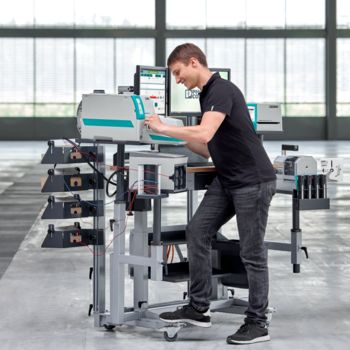 Person standing in front of the clipx WIRE assist worker assistance system, marking a wire with a printing system