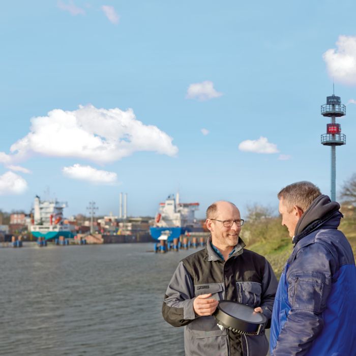 Gespräch zweier Personen vor einer Schleuse mit Signalanlagen 
