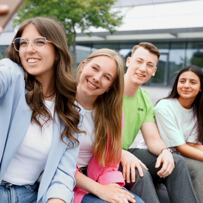 Junge Menschen schauen sich einen Versuchsaufbau an