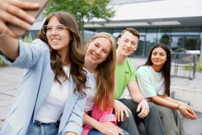 Junge Mitarbeitende sitzen zusammen und unterhalten sich