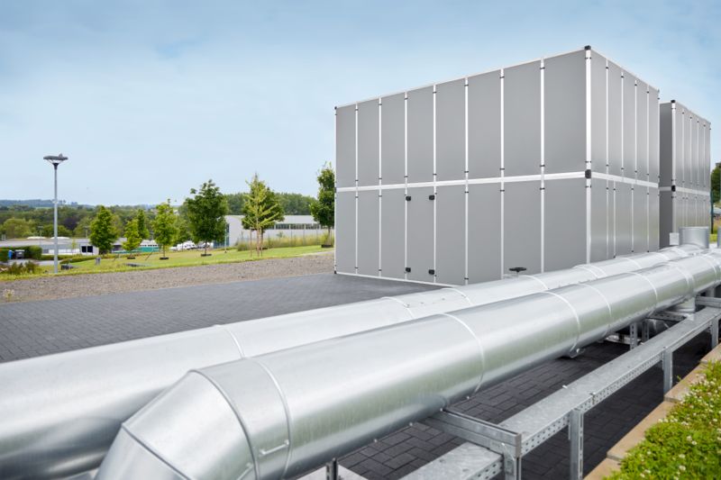 Container against a blue sky with adjacent pipelines