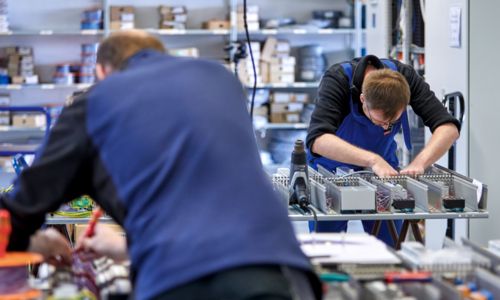 Verdrahtung eines Schaltschranks durch zwei Mitarbeitende