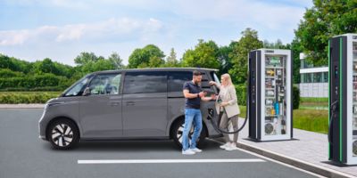 Une femme charge sa Volkswagen ID.3 à une station de charge HPC