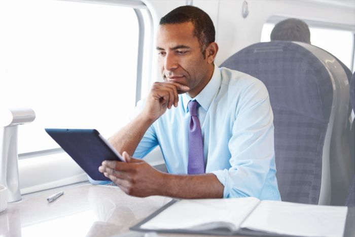 Businessman on a train uses a Phoenix Contact app