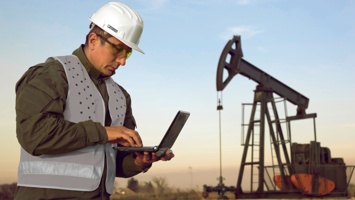 Man with tablet captures data from oil and gas production sites