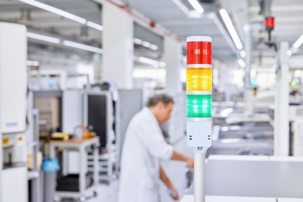 Medarbetare i en produktion med ljustorn
