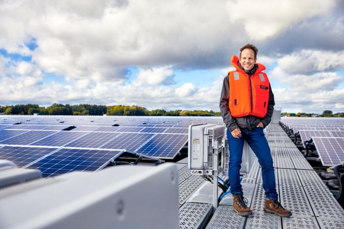 Mann mit Schwimmweste auf Solarpanel