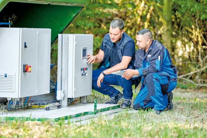 Två tekniker arbetar med automationsteknik för vattenutvinning