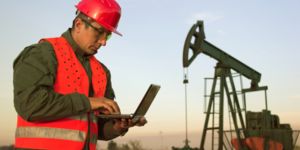 Trabalhador em uma plataforma petrolífera com laptop nas mãos