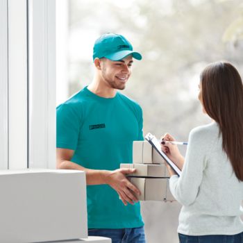 Customer receiving a package at the door from a delivery agent