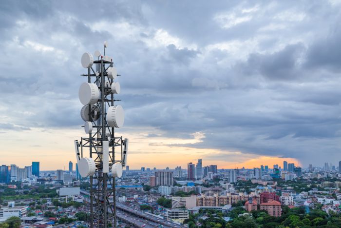 Telecommunications mast against a city backdrop