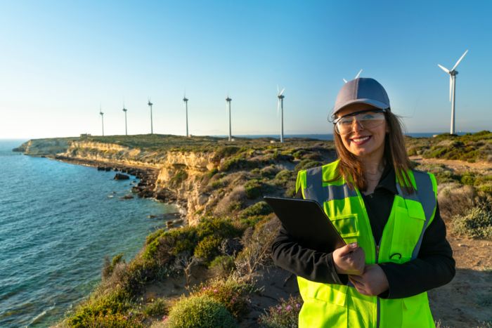 Frau mit Kappe vor Windrädern