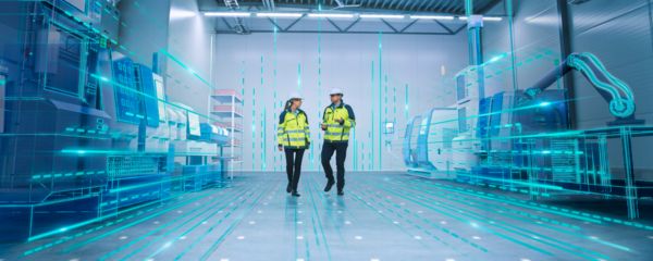 People in a production hall with the schematic view of a DC grid