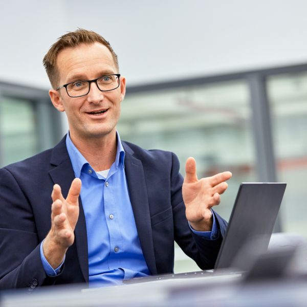 Stephan Volgmann sitzt an einem Schreibtisch und wird interviewt 
