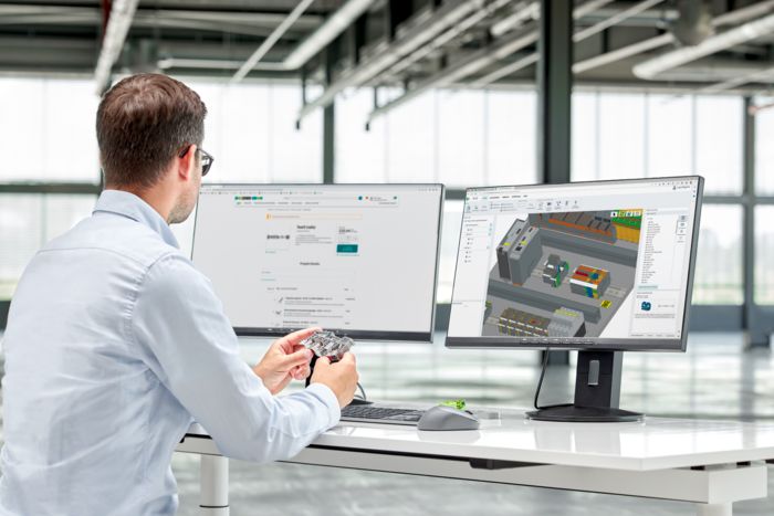Person am Arbeitsplatz mit Klemme in der Hand
