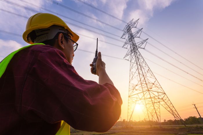 Person at an electricity mast with wireless device in hand