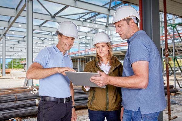 Gesprächssituation auf der Baustelle: Planung eines Smart Buildings