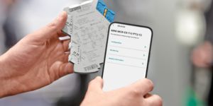 Hand met MINI Analog Pro Ex-i-scheidingsversterker en mobiele telefoon met Signal Conditioner App