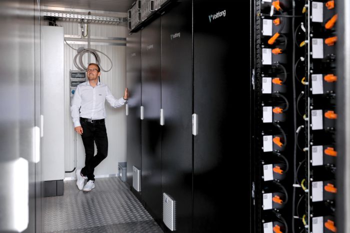 Blick in einen Batteriespeicher in dem eine Person steht