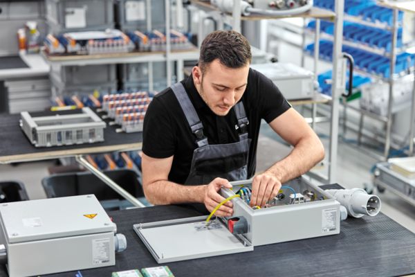 Mann fertigt einen individuellen Klemmenkasten