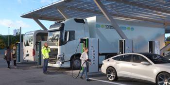 Moderner Ladepark mit HPC-Ladestationen, an denen mehrere Elektroautos, ein Elektro-Lkw und ein Elektrobus geladen werden