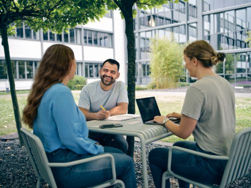 Mitarbeitende sitzen in einem Meeting zusammen