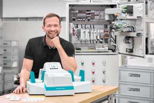 Person with the Bluemark&nbsp;E.Card UV inkjet printer in front of a control cabinet